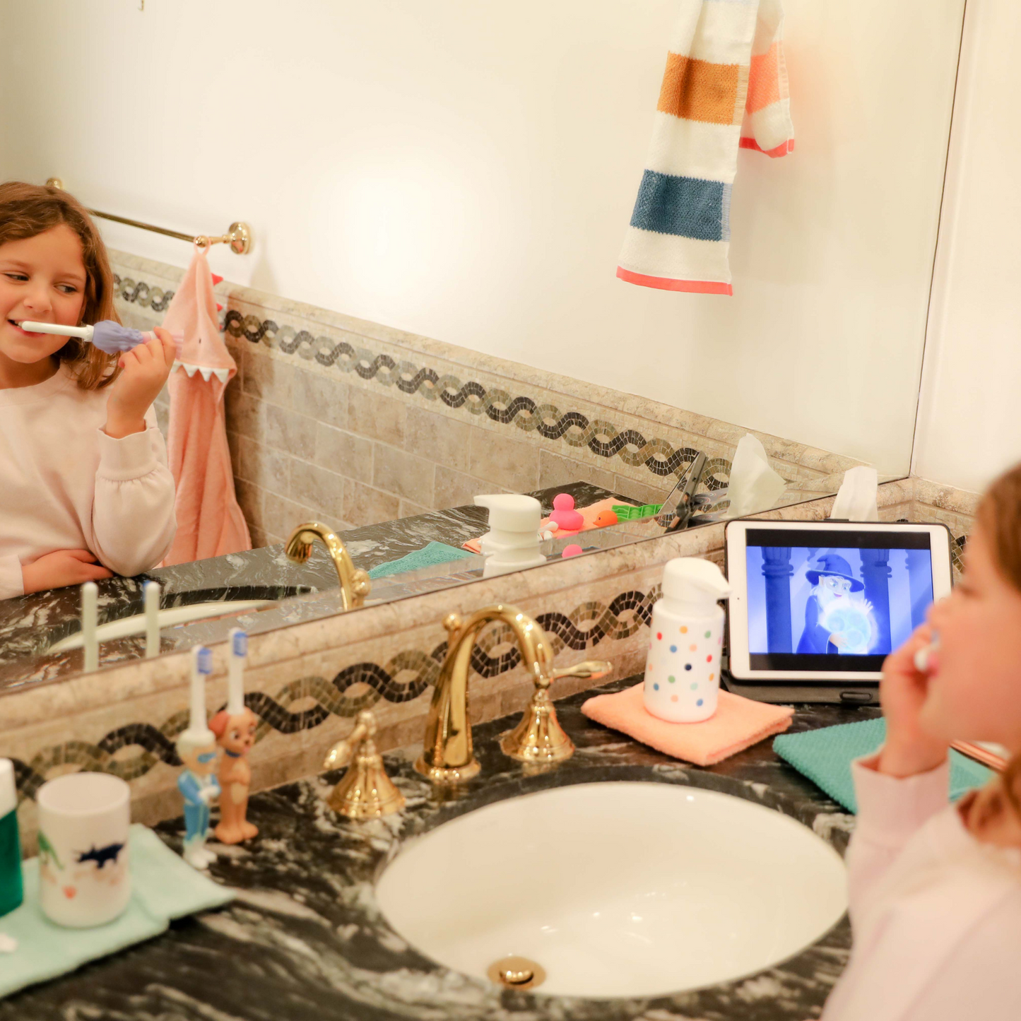 girl watching ipad while brushing teeth